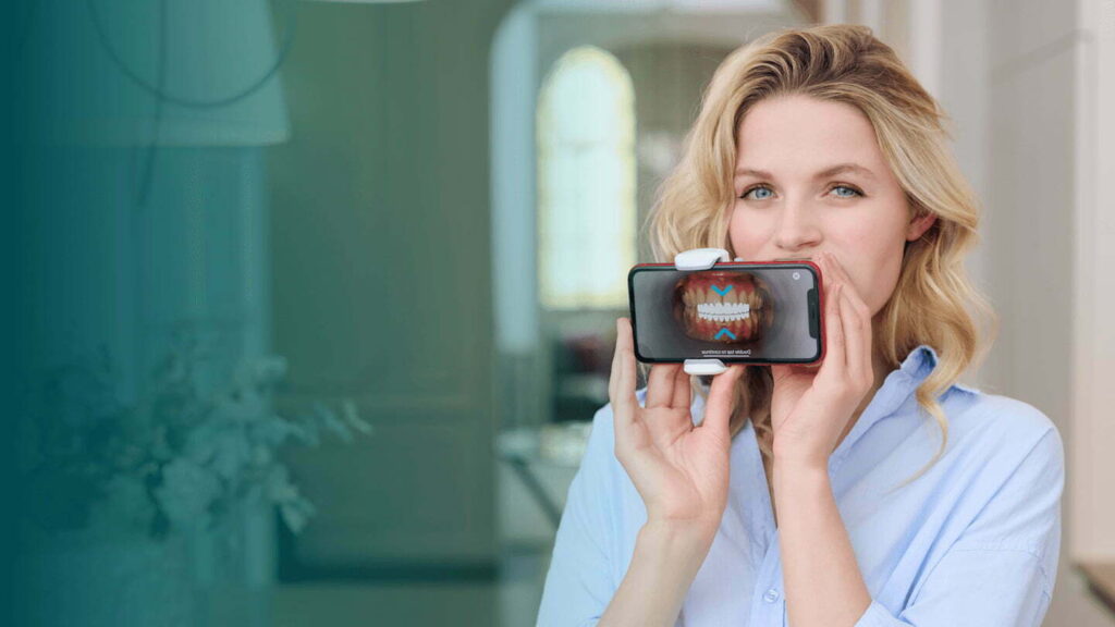 A woman using dental monitoring technology